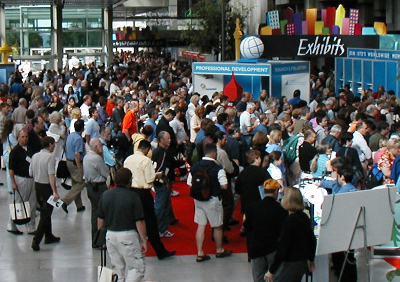 Photo of a large conference hall with hundreds of people walking through to their conference, for the CPE homepage.