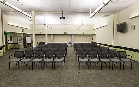 Large open classroom with several rows of chairs in lecture style seating for Eugene Event Facilities page.