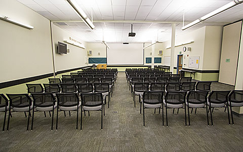 Medium sized open classroom with several rows of chairs in lecture style seating for Eugene Event Facilities page.